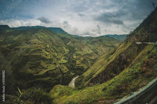 Canvas Print Lush and deep green valleys with heavy clouds above on the road between Ecuador and Colombia