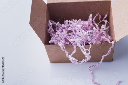 Box filled with shreddered purple paper. Isolated on white.