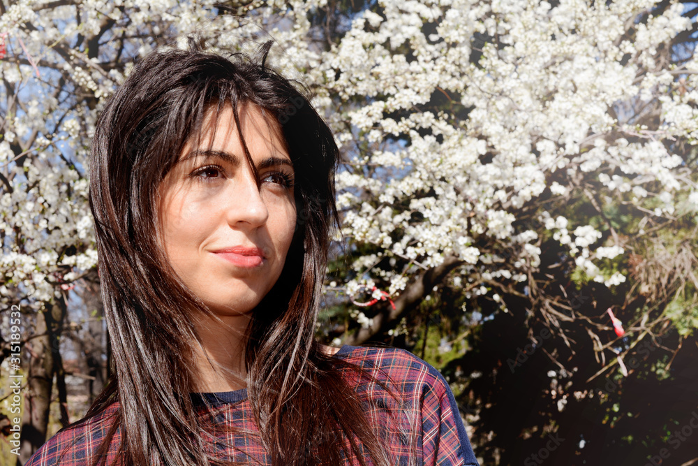 Beautiful Young Woman on a Spring Blooming Tree Background 