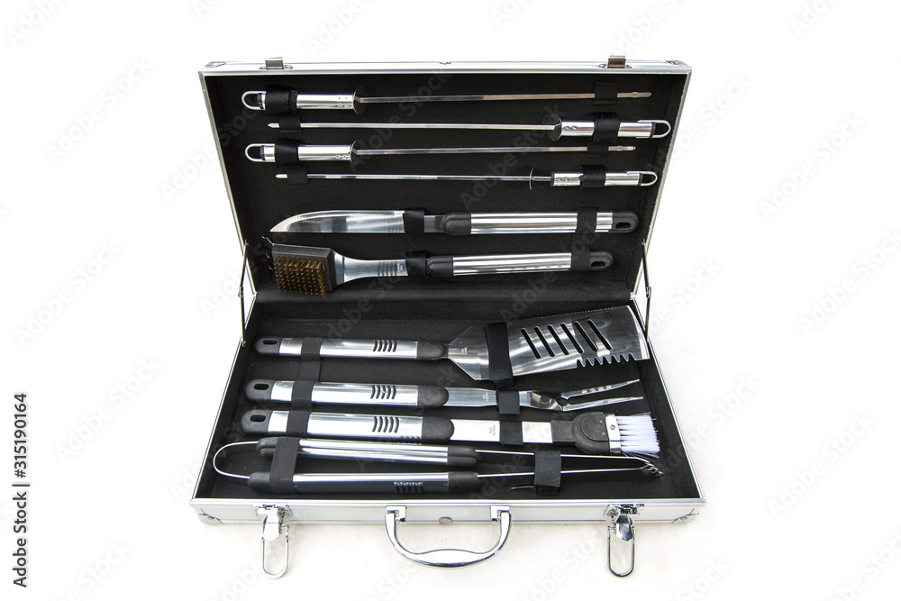 Set of barbecue or grill tools utensils in a metal box isolated on white. Set consisting of tongs, brushes, knives, forks and so on. Set of barbecue or grill tools utensils in a metal box isolated on white. Set consisting of tongs, brushes, knives, forks and so on.
