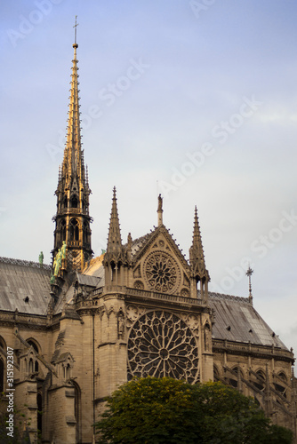 Gorgeous sunset over Notre Dame cathedral with puffy clouds, Paris, France.Notre Dame de Paris - Gothic Catholic Cathedral with rose window and gargoyle sculptural decorations at 2016.