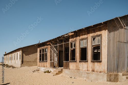 Abandoned buildings left to rot in wild west scenery with desert sand © wideeyes
