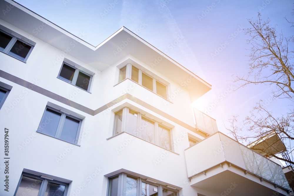 Modern apartment buildings on a sunny day with a blue sky. Facade of a modern apartment building.Glass surface with sunlight. Modern apartment buildings on a sunny day with a blue sky. Facade of a modern apartment building.Glass surface with sunlight.