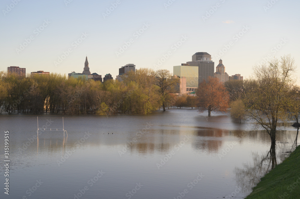 medium wide angle view of a flooded football field with the city of Hartford, CT in the distance.