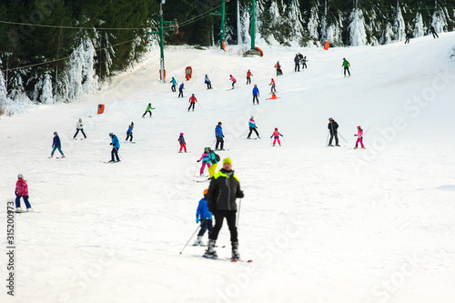 Skiers and snowboarders going down the slope at Donovaly ski resort in Slovakia