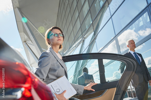 Businesswoman arriving at airport getting out of town car photo