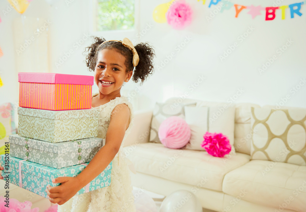 Portrait smiling girl carrying stack of birthday gifts Portrait smiling girl carrying stack of birthday gifts