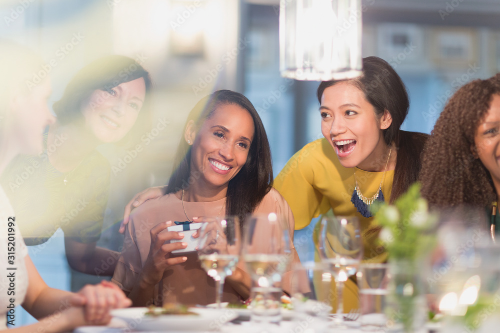Smiling women friends celebrating birthday at restaurant table Smiling women friends celebrating birthday at restaurant table