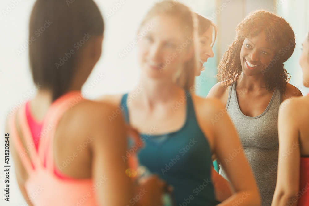Smiling women talking in exercise class gym studio