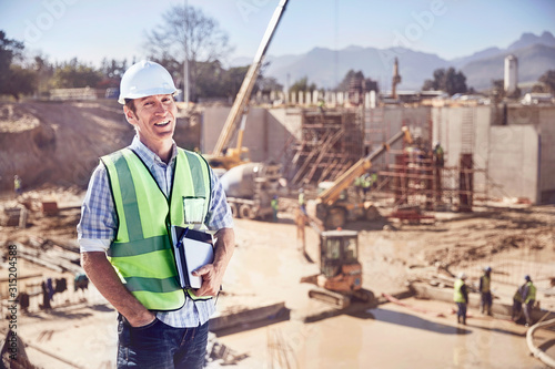 Fototapeta Portrait confident construction worker foreman at sunny construction site