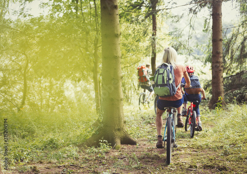 Family mountain biking on trail in woods photo