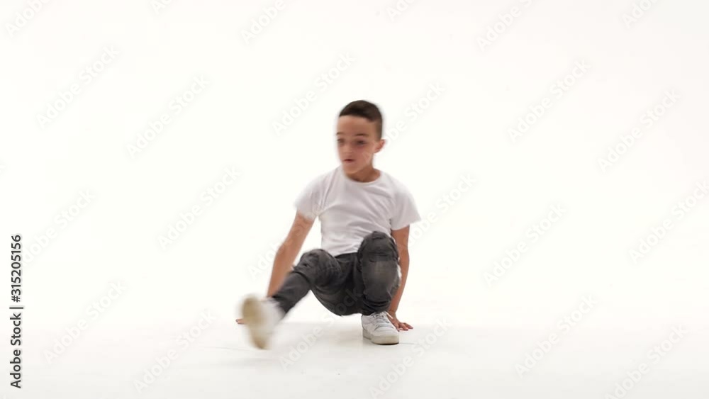 Little boy is dancing a modern dance on the white background in black leather jackets and jeans. Slow motion. Little boy is dancing a modern dance on the white background in black leather jackets and jeans. Slow motion.