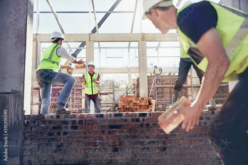Construction workers bricklaying at construction site photo
