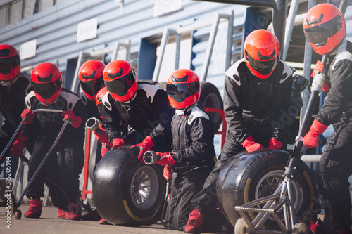 Pit crew ready with tires in formula one pit lane photo