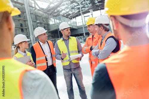 Foreman, engineers construction workers meeting at construction site
