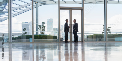 Businessmen talking in doorway of urban highrise building