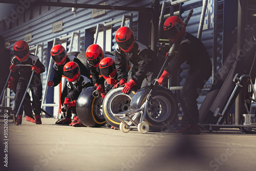 Pit crew preparing tires in formula one pit lane