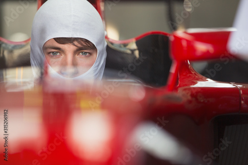 Close up portrait serious formula one race car driver wearing protective mask