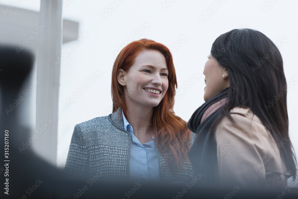 © Martin Barraud/Caia Image - Smiling businesswomen talking outdoors