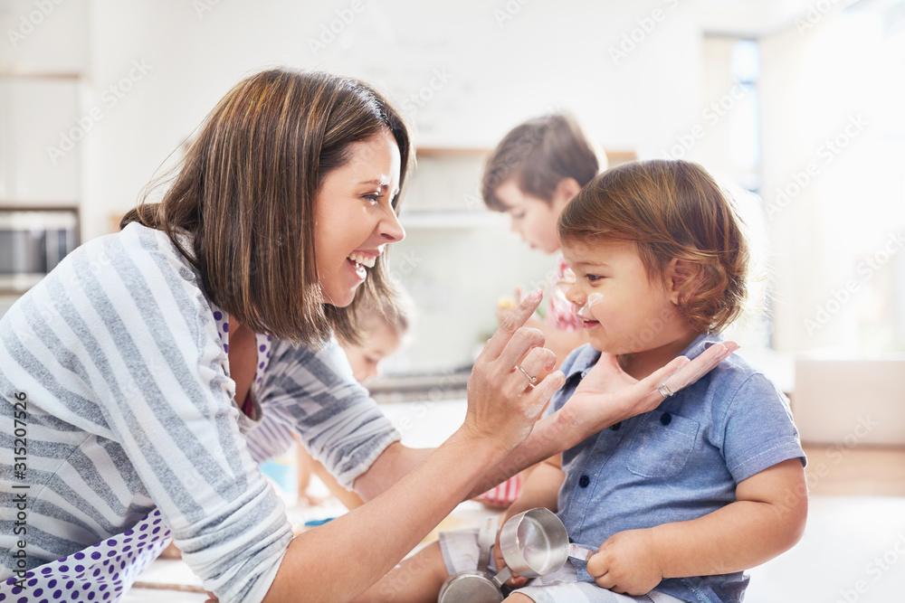 Playful mother and son with flour on nose baking in kitchen Playful mother and son with flour on nose baking in kitchen