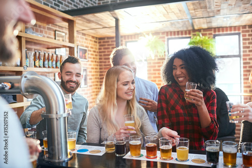 Friends sampling, drinking beer in pub photo