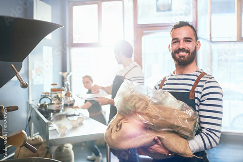 Portrait smiling, confident male coffee roaster