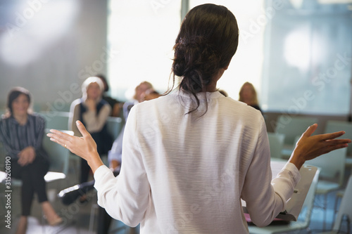 Businesswoman gesturing, leading conference room meeting