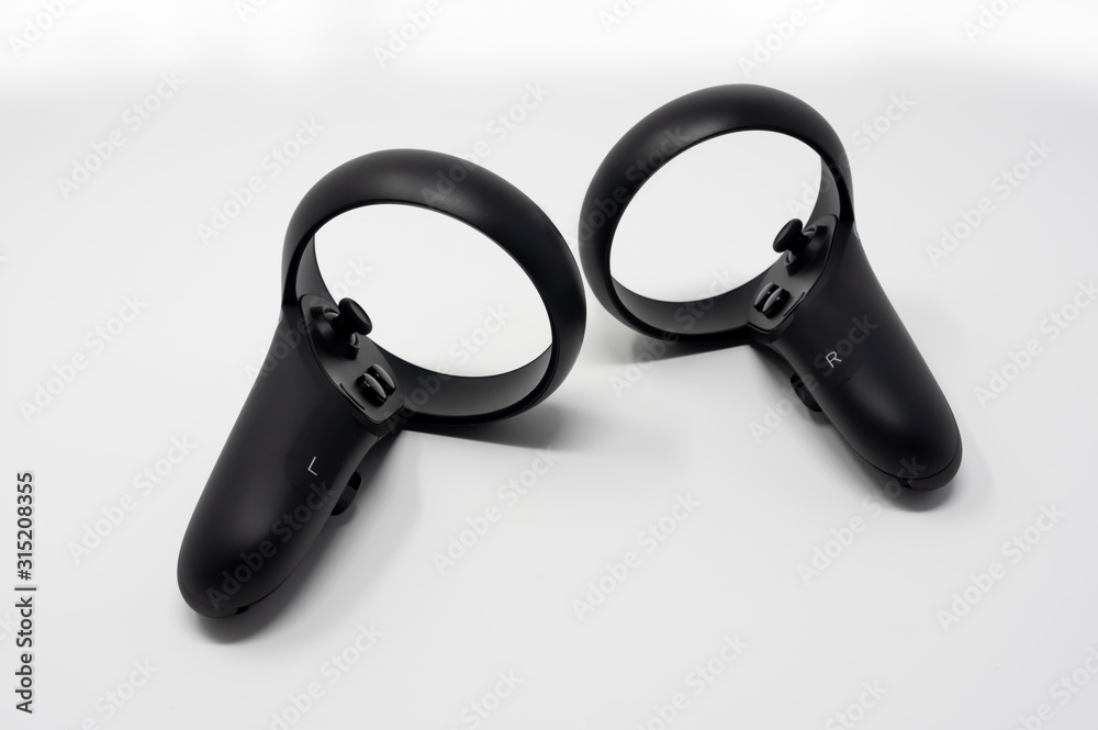 Black motion controllers with triggers, buttons, analog sticks and touch. Made for virtual reality video games. Black motion controllers with triggers, buttons, analog sticks and touch. Made for virtual reality video games.