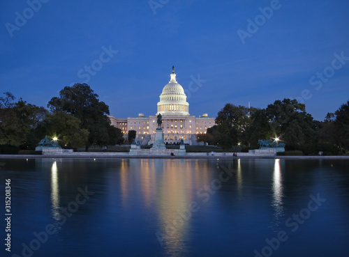 Beleuchtetes Kapitol (Capitol), amerikanischer Kongress, in Washington D. C. (USA) bei Nacht mit Reflektion im Wasser und blauem Himmel