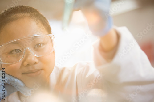 Pensive girl student conducting science experiment in classroom laboratory