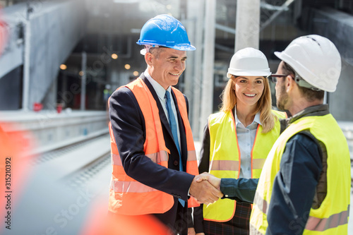 Businessman and engineer handshaking at construction site