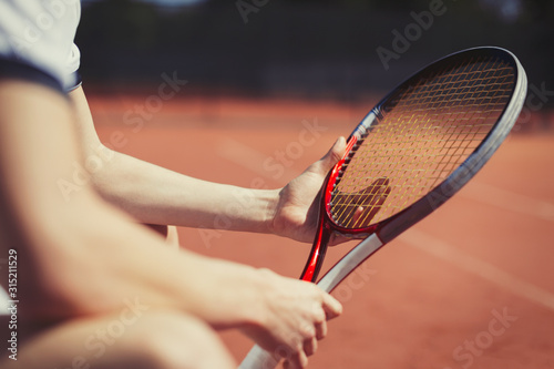 Young male tennis player holding tennis racket photo