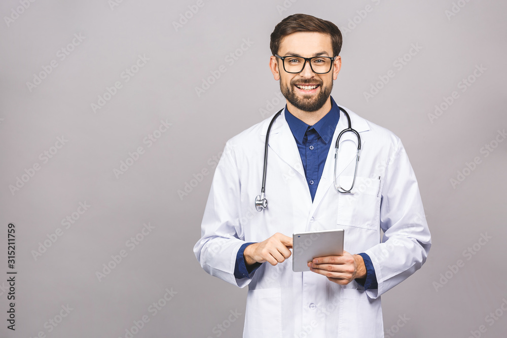 Smiling doctor using a tablet computer isolated on a grey background. Smiling doctor using a tablet computer isolated on a grey background.
