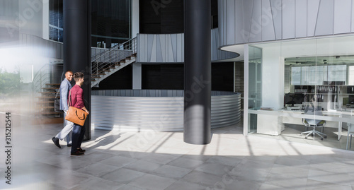 Businessmen walking in modern office lobby photo