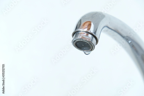 A close up of a  water drop on the faucet