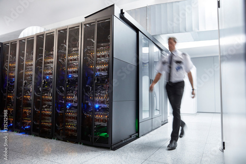 Male security guard walking in server room photo