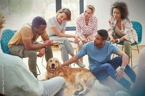 People petting dog in group therapy session photo