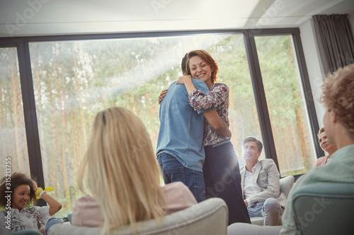 Man and woman hugging in group therapy session photo