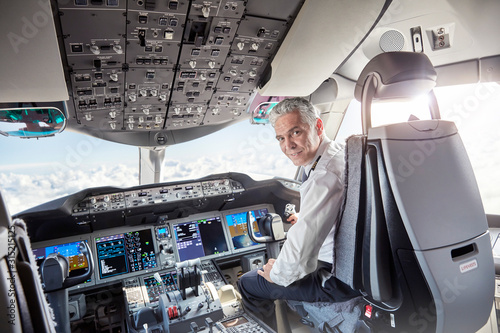 Portrait confident male pilot in airplane cockpit photo