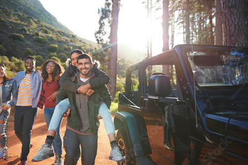 Portrait playful young friends enjoying road trip outside jeep photo
