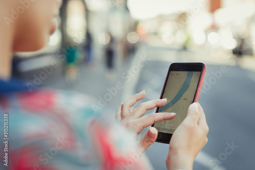 Close up woman using smart phone GPS on street