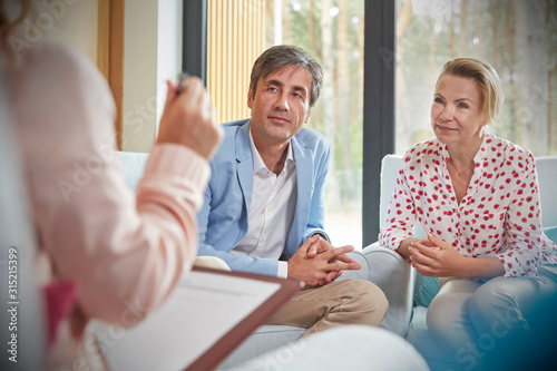 Couple listening to therapist in couples therapy counseling session photo