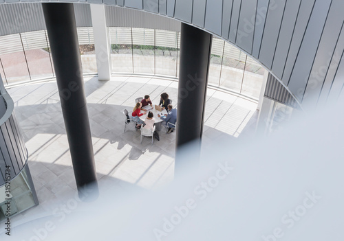 Business people meeting at table in modern office atrium photo