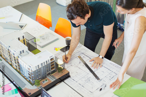 Architects drafting blueprint in office photo