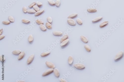 Many brigtht pumpkin seeds scattered around. White isolated background.