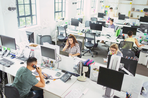 Business people working at desks in open plan office photo