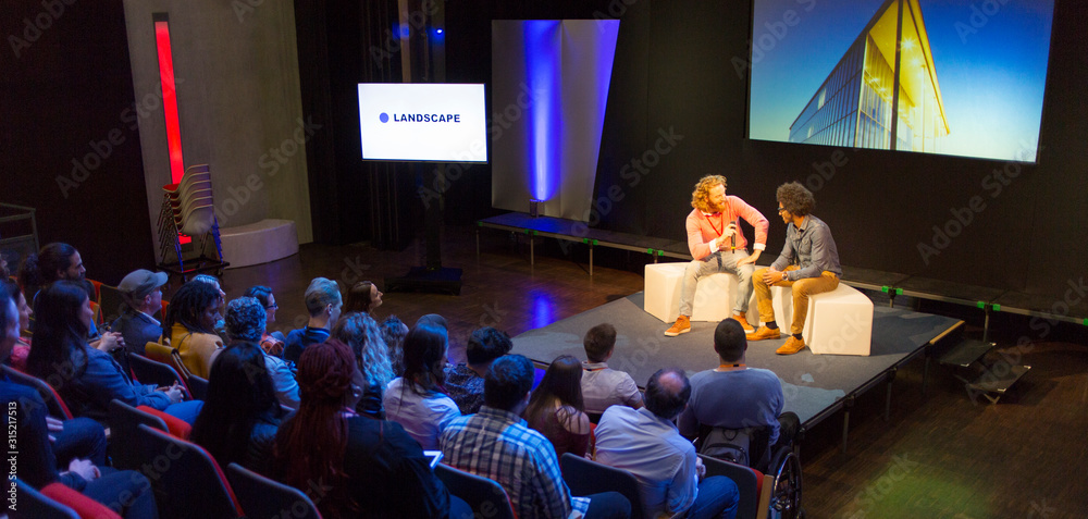 © Martin Barraud/Caia Image - Audience watching speakers talking on stage