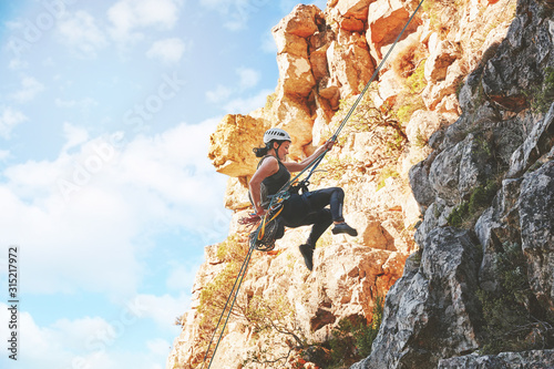 Female rock climber descending rocks