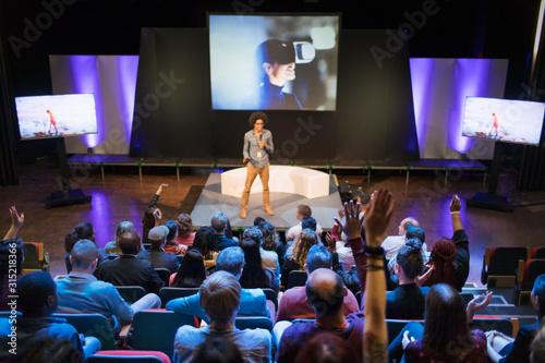 Male speaker on stage answering audience questions
