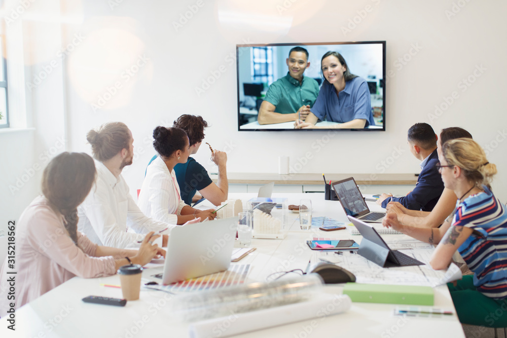 Designers video conferencing with colleagues in conference room meeting Designers video conferencing with colleagues in conference room meeting